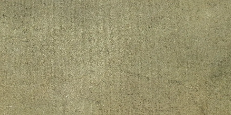 Close-up of a glossy moss green ceramic tile face with a soft yellow-olive tone and gentle variation.