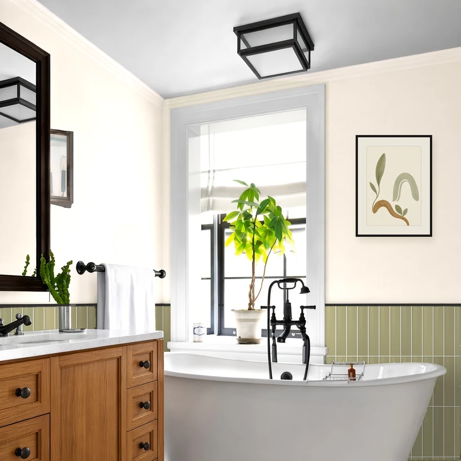 Illustrative render of a bathroom with warm linen walls, moss green tile in a vertical stack with black edge trim, a natural oak vanity and matte black hardware and fixtures.